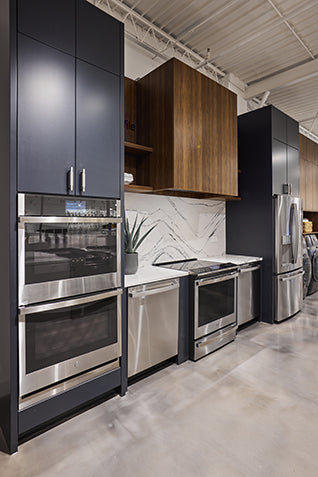 Modern kitchen with stainless steel appliances and dark cabinets.