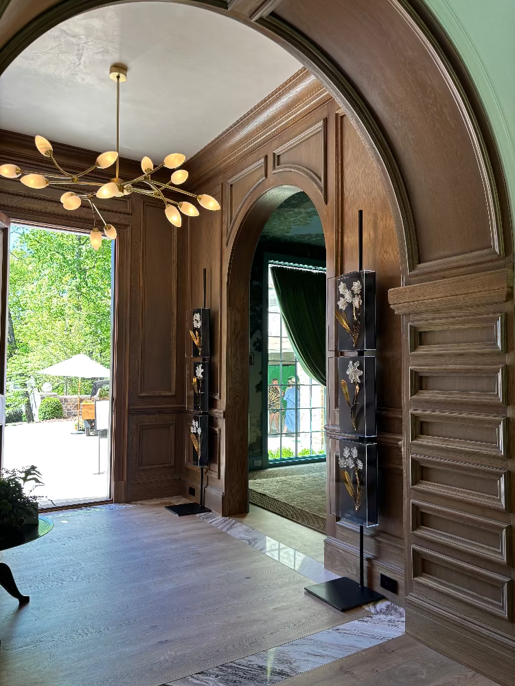 Luxurious interior with wooden archway, chandelier, and outdoor view