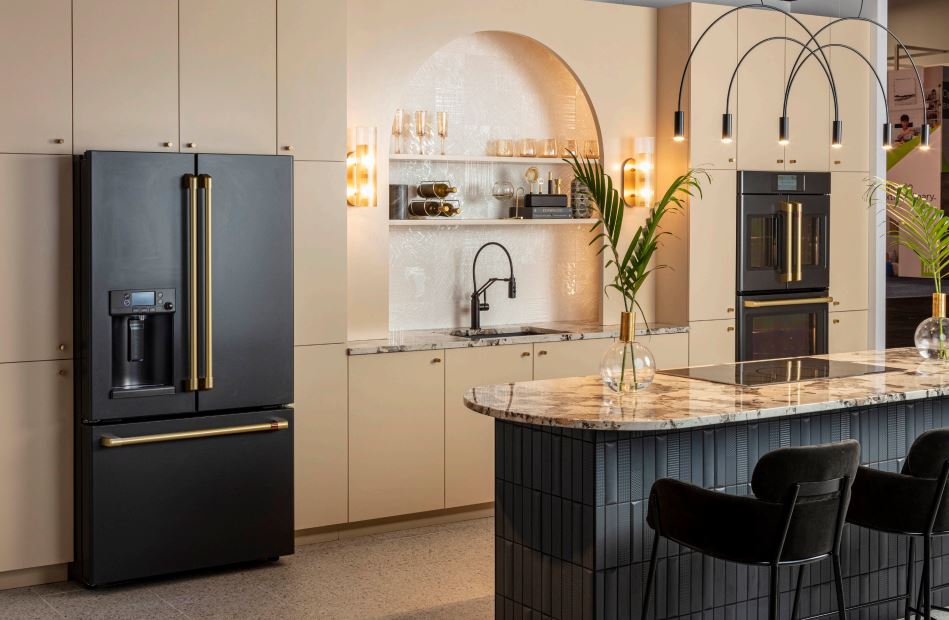 Modern kitchen with black refrigerator, island, and bar stools.