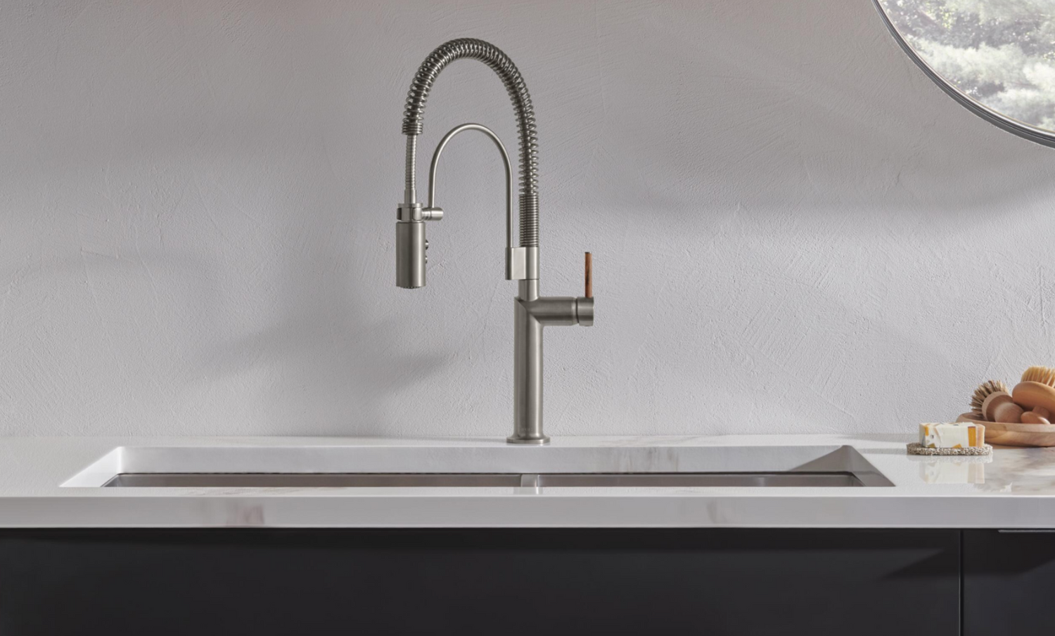 Modern kitchen sink with a silver faucet against a neutral background