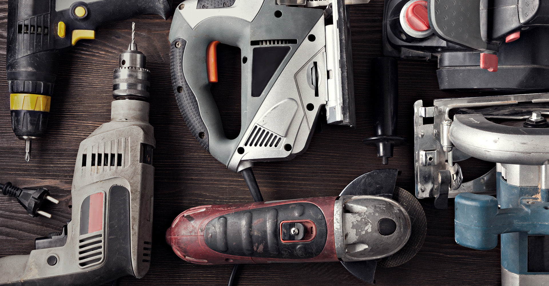 Collection of power tools on a wooden surface