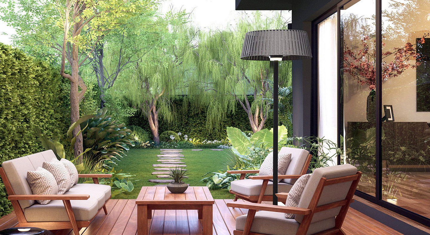 Outdoor patio area with chairs, table, a tall lamp that also acts as a heater, and a garden view
