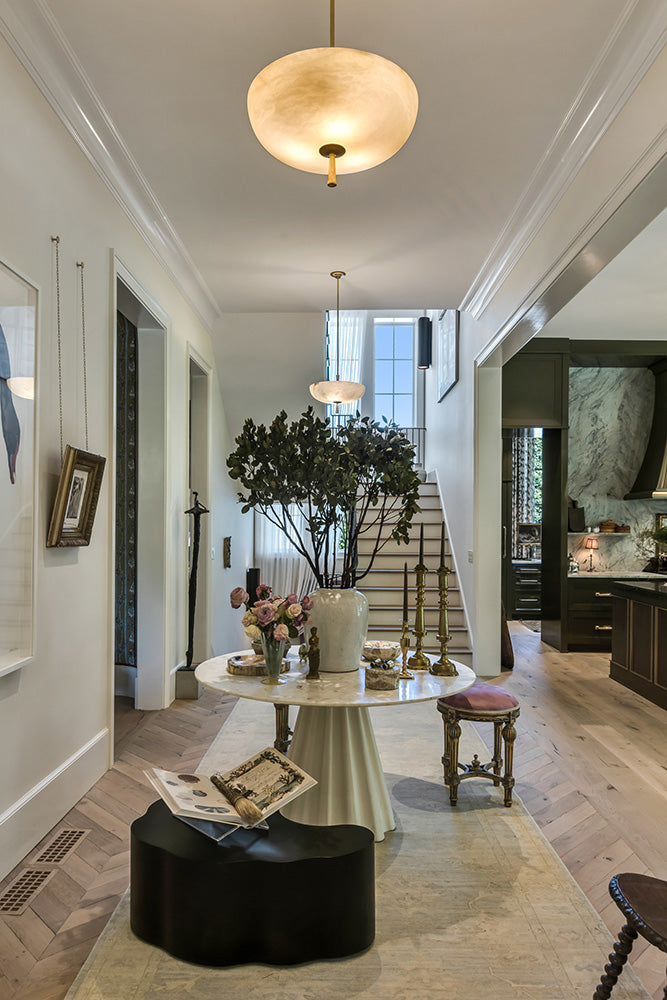 Entry of the Southeastern Designer Showhouse with a circular table and pendant lights