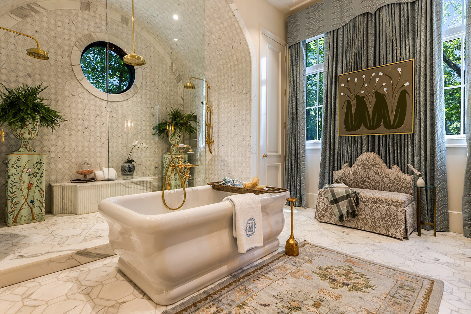 Luxurious bathroom with freestanding bathtub, decorative rug, and elegant decor.